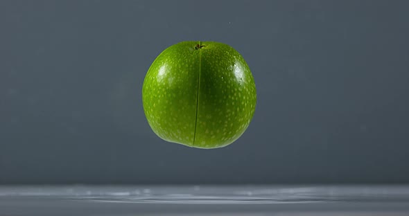 Granny Smith Apple, malus domestica, Fruit falling on Water against Black Background, Slow Motion 4K