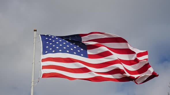 Large US Flag on a Background of Gray Sky Beautifully Illuminated By the Sun