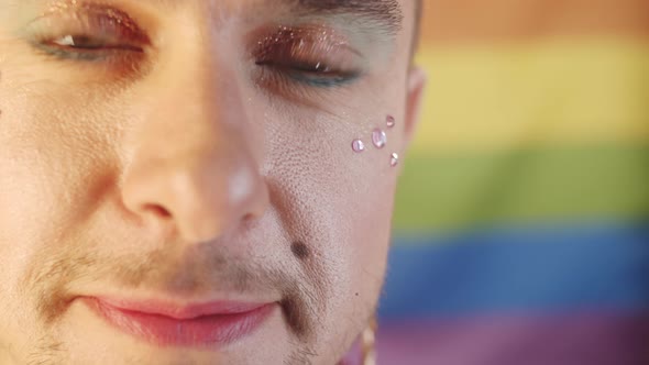 Happy Gay Man with Makeup and Face Gems Smiling at Camera