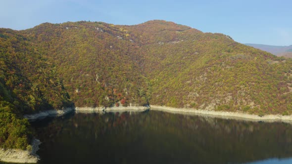 Reflection in lake of mountain forest with autumn colors, aerial view