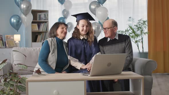 Family Celebrating Graduation Ceremony and End of Academic Year Online Sitting in Living Room with