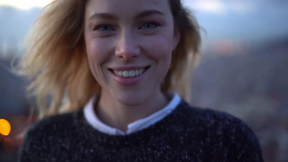 Portrait of happy woman with city lights in background