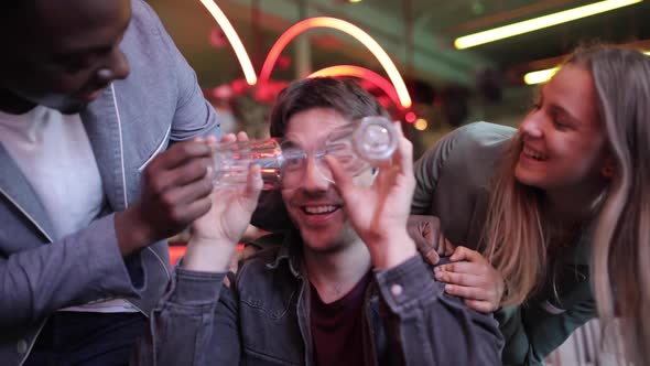 Happy friends having fun at bar with empty glasses, slow motion