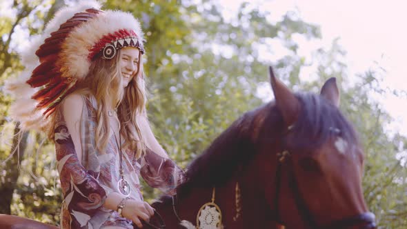 Young Woman In Headdress Riding Horse In Sunlit Forest
