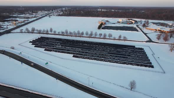 Aerial view of field with solar panels covered in snow