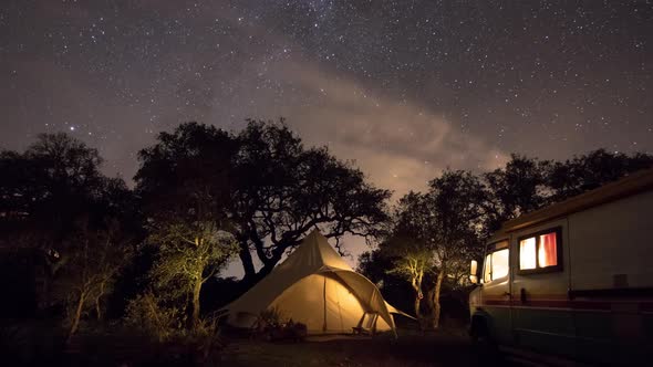 Dazzling night sky sweeps over camp site, time lapse