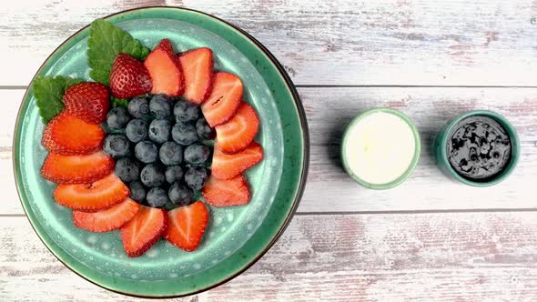 Dessert with Strawberries and Blueberries with Yogurt or Whipped Cream Rotate Slowly on Turntable