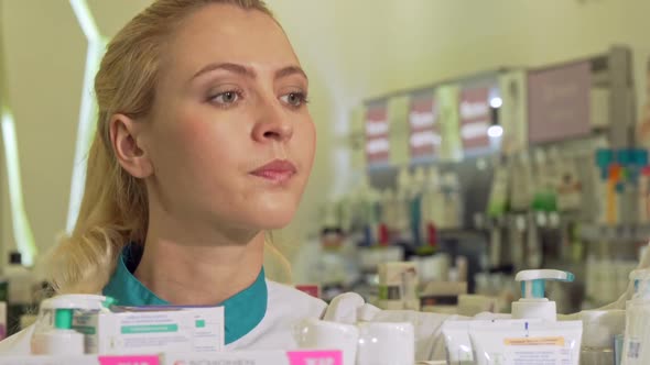 Female Pharmacist Organizing Products on a Shelf, Working at Drugstore t