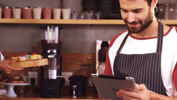 Waiter using digital tablet at caf������������