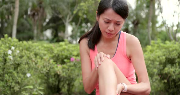 Sport woman getting hurt on legs at outdoor park