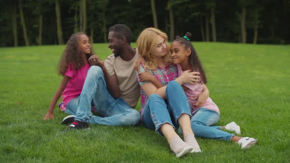 Two Loving Daughters Embracing Parents in Nature