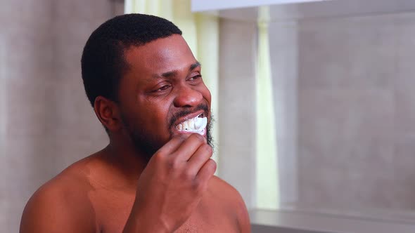 Africa Man Toothbrush in Bathroom Looking at Mirror