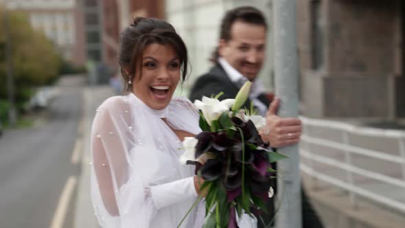 Happy Newlyweds in City Man and Woman Dressed Wedding Clothes are Playing on Street