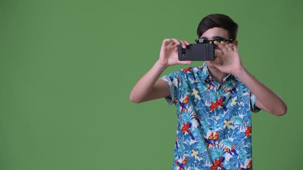 Young Handsome Iranian Teenage Boy Ready for Vacation Against Green Background