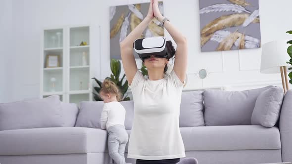 Young Woman in Virtual Reality Headset which Doing Yoga Exercises on the Floor