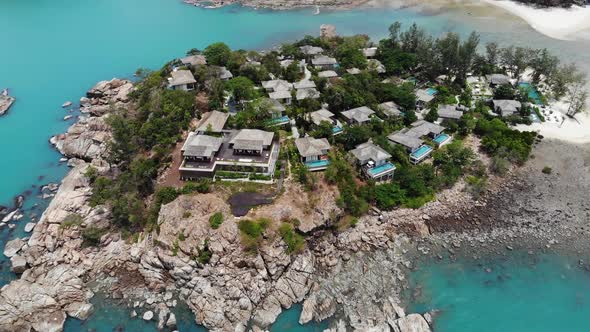 Bungalows on Rough Shore Near Sea. Many Tropical Cottages Located on Rough Coast Near Calm Turquoise