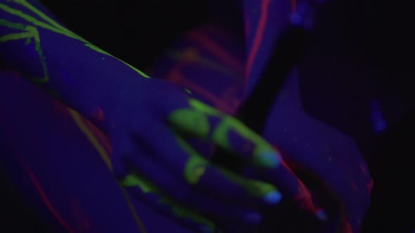 Beautiful Woman Inhaling Hookah in Fluorescent Clothing Under UV Black Light