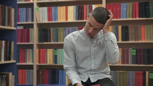 Tired young man in the library