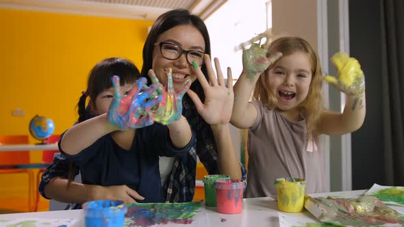 Kids and Teacher with Hands in Paint at Art Lesson