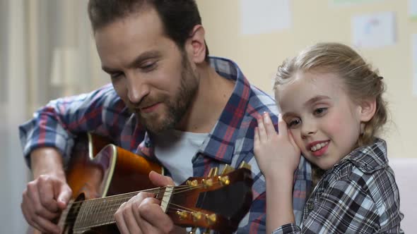 Little Girl Hugging and Listening Father Playing Guitar, Creative Home Leisure