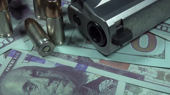 Close Up Of Pistol Bullets and Hundred Dollar Bills