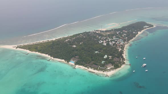 Top view of an island located in the Maldives, on which the city is located, surrounded by the incre
