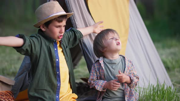 Outdoor Recreation Cute Children Have Fun Outdoors Sitting in a Tepee Among the Trees in a Meadow on