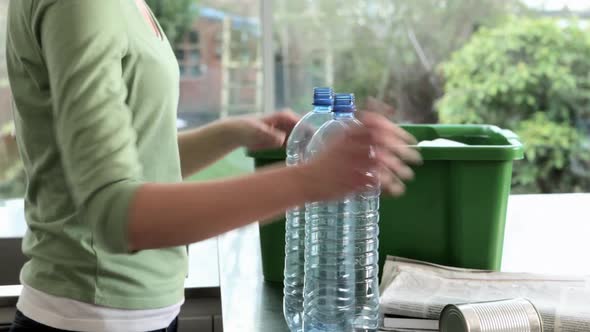 Woman putting objects in box for recycling