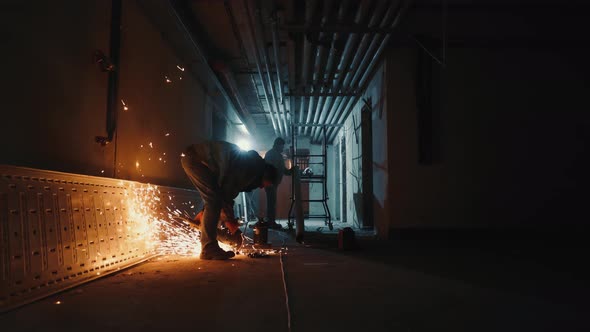 A Heavy Industry Worker Cuts a Metal Pipe