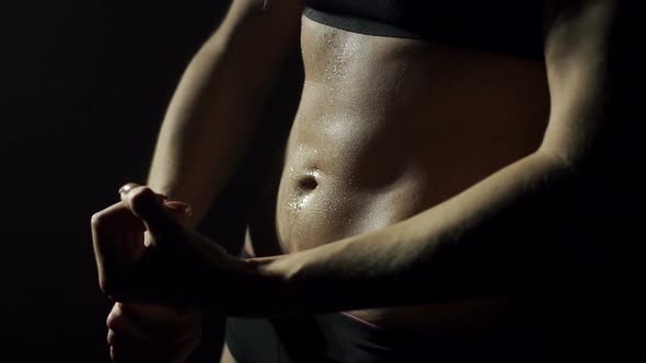 Closeup of Belly Athletic Girl on Black Background