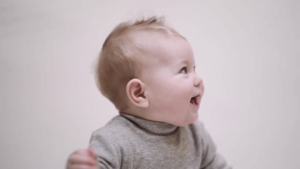 portrait of a 6-month-old baby on a light background and smiling