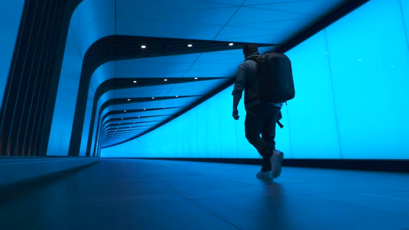Low Angle Following Shot of Man Walking Through Vibrant Tunnel in London, United Kingdom