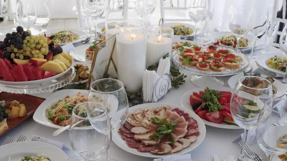 Variety of Snacks Salads Meat Delicacies are in Plates on Decorated Table