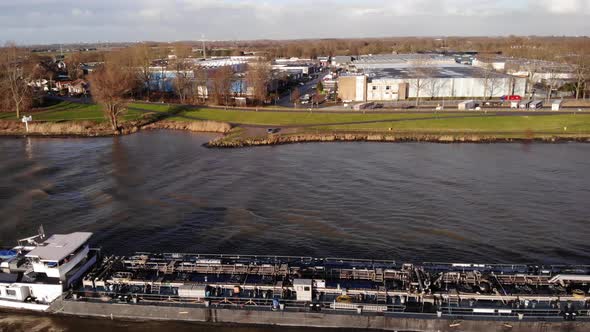 Aerial Flying Over Past Liquid Tanker On Oude Maas With View Of Large Building In Background In Zwij