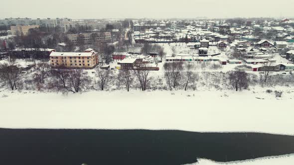 Fabulous Winter Landscape with a Frozen River and Suburbs Aerial View