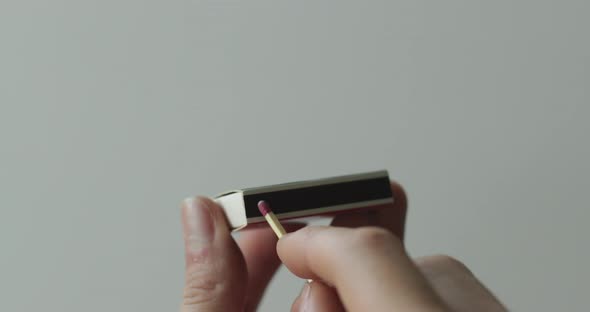 Striking a match on a matchbox with white background