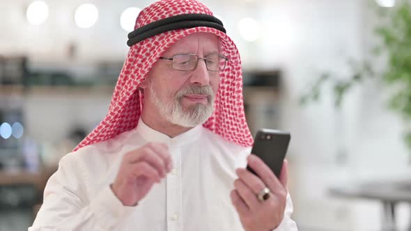 Senior Old Arab Businessman Celebrating Success on Smartphone