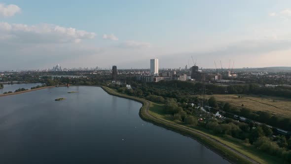 Rising drone shot of power lines heading into central London Walthamstow reservoirs