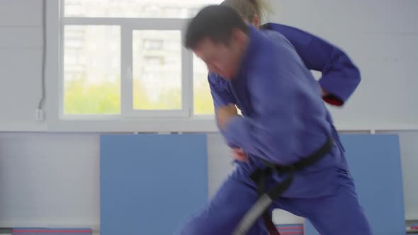 Male and Female Sparring Partners Practicing Jiu-Jitsu Fight