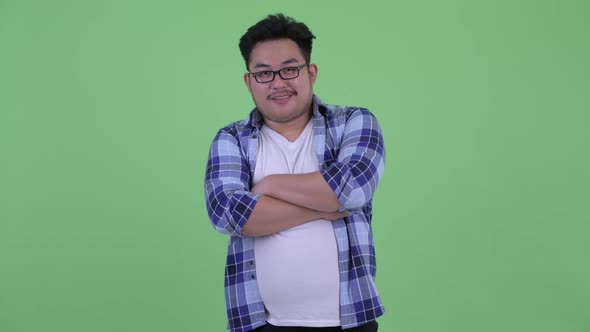 Happy Young Overweight Asian Hipster Man Smiling with Arms Crossed