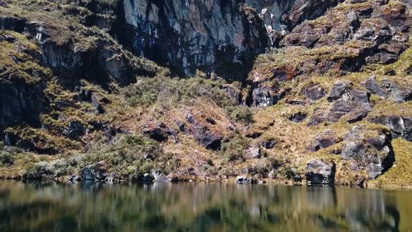 4K daytime video  with a golden mountain side reflecting into the clear and cold water of a lake on