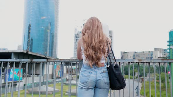 From behind young woman looking city panorama dreamlike