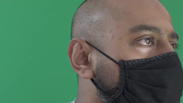 Adult Male With Face Mask Looking Off Screen. Right Side Face View. Green Screen, Locked Off