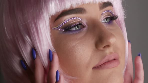 Beautiful Young Girl Model Posing in a Pink Short Bob Wig Rhinestones on Her Eyes and Stylish Pink