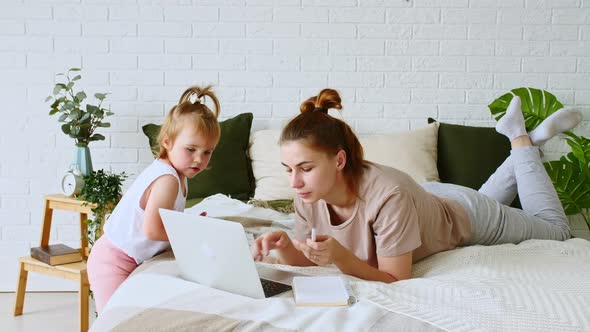 Mother Working From Home Having a Work Video Call While Her Child Distracts and Drawing Attention