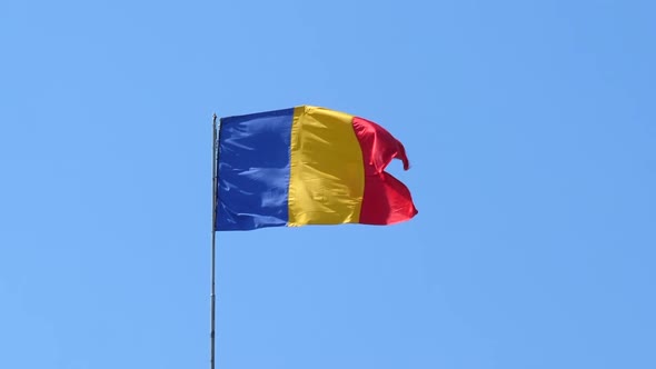 Romanian Tricolor Flag Fluttering in the Wind, Blue Sky Background.