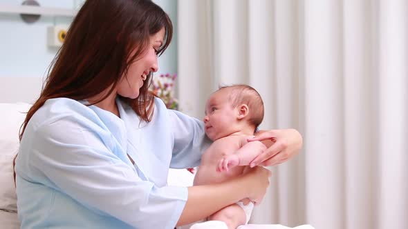 Smiling mother embracing a new born baby