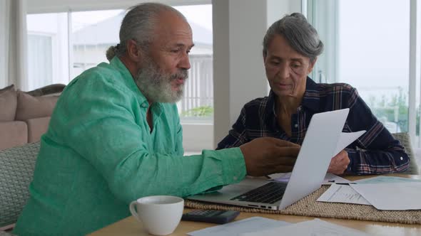 Mature couple using laptop at home