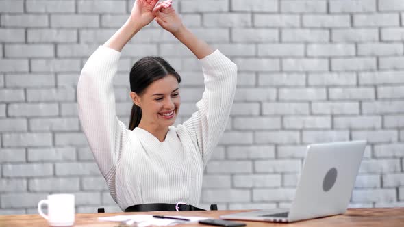 Businesswoman Celebrating Successful Deal or Finance Profit at Desk