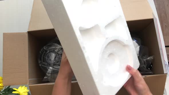 A Woman Opens A Box With A Food Processor.